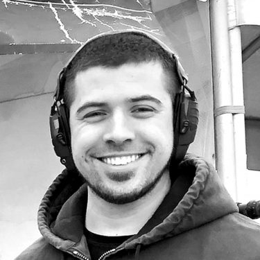 Black-and-white photo of a man with shooting earmuffs